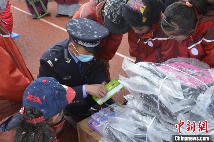 2020年6月1日，多玛边境派出所与驻地小学开展共建活动，张思祖向学生发礼物。　受访者供图